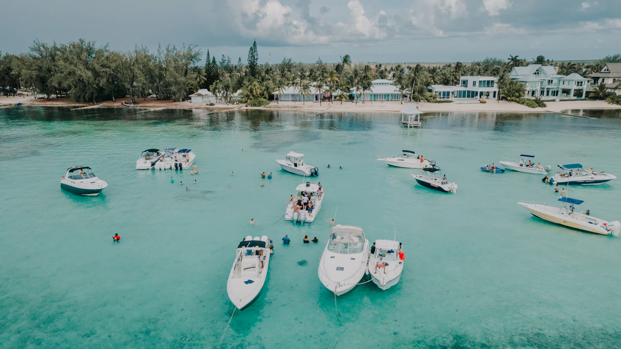 Boote ankern im türkisen Flachwasser vor dem Strand von Grand Cayman