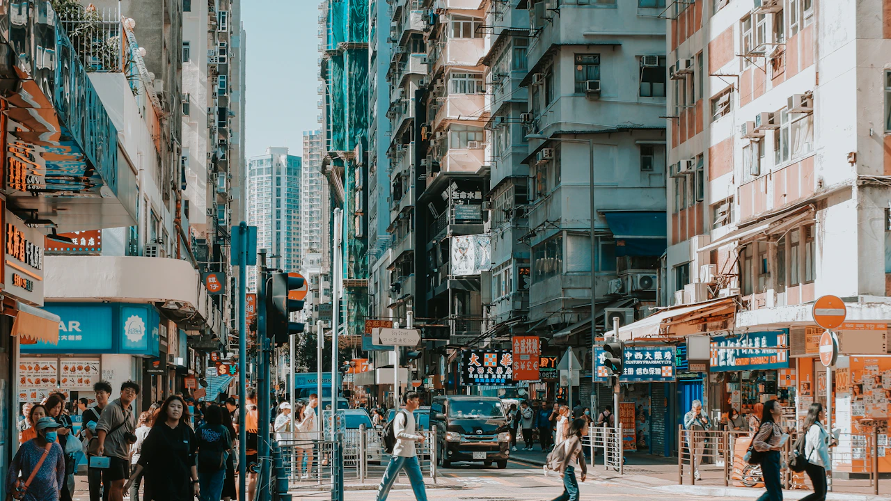 Alltagsszene an einer Straßenkreuzung zwischen Wohnhochhäusern in Hongkong